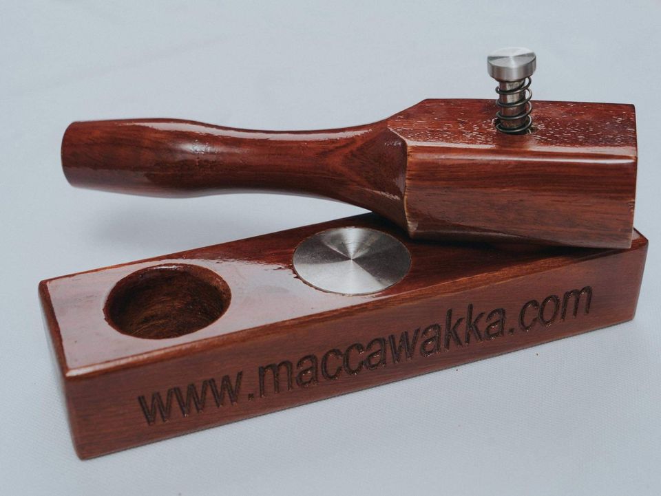 The MaccaWakka macadamia nut cracker on its own: hardwood base with two cups and the hammer resting on top