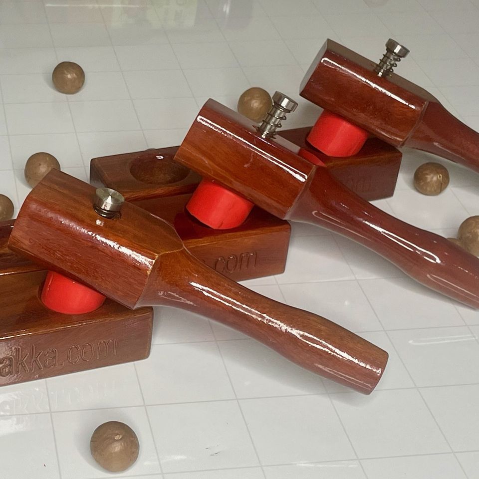 Three MaccaWakka macadamia nut crackers with red silicone cups, fresh from the workshop